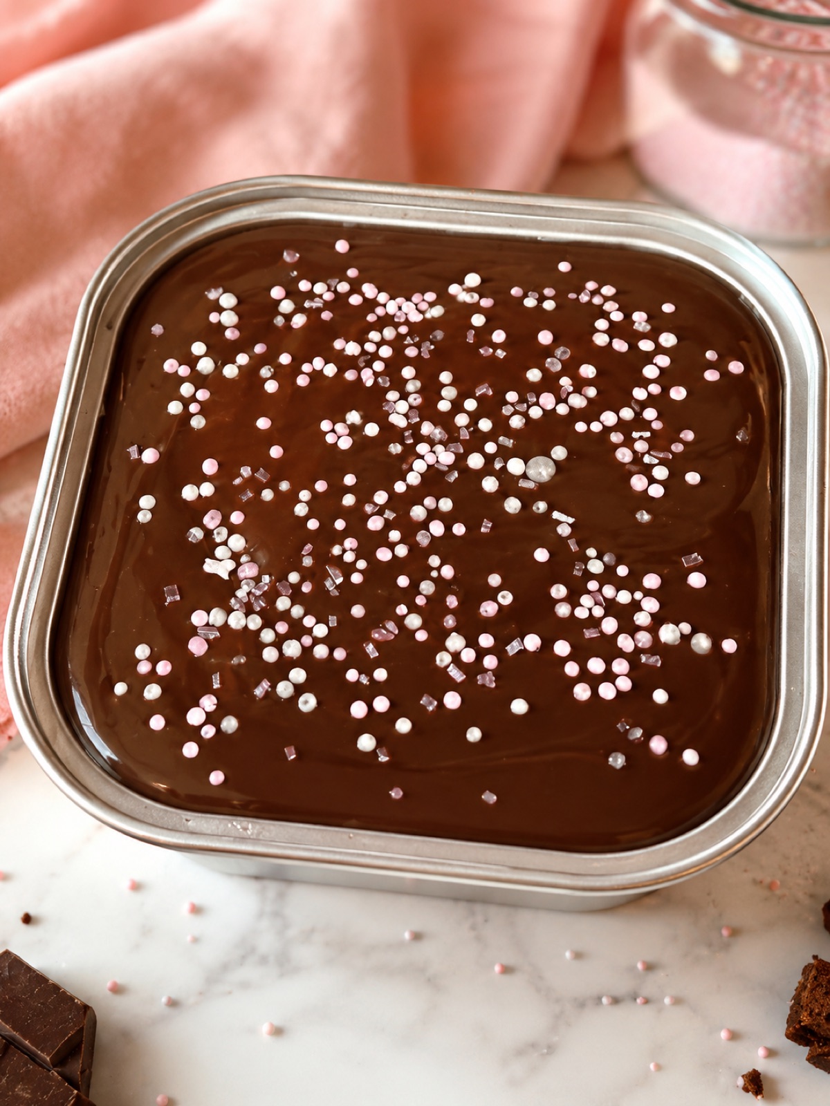 Seven tins of sprinkle brownies on a wooden board