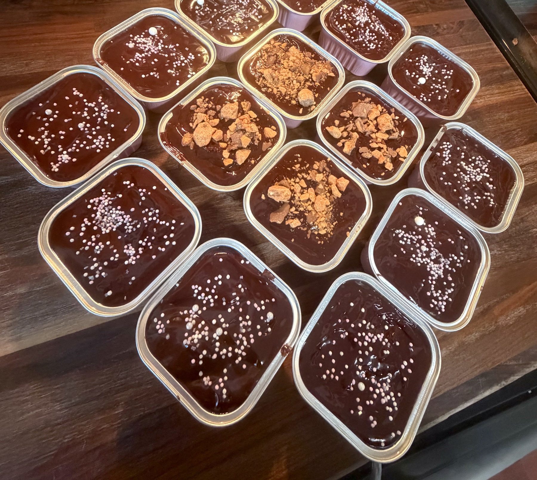An assortment of Heather's chocolate-topped dessert tins with sprinkles and candy pieces